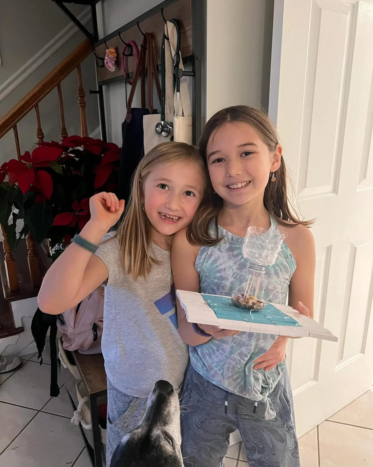 Two sisters hold their finished bird feeder.