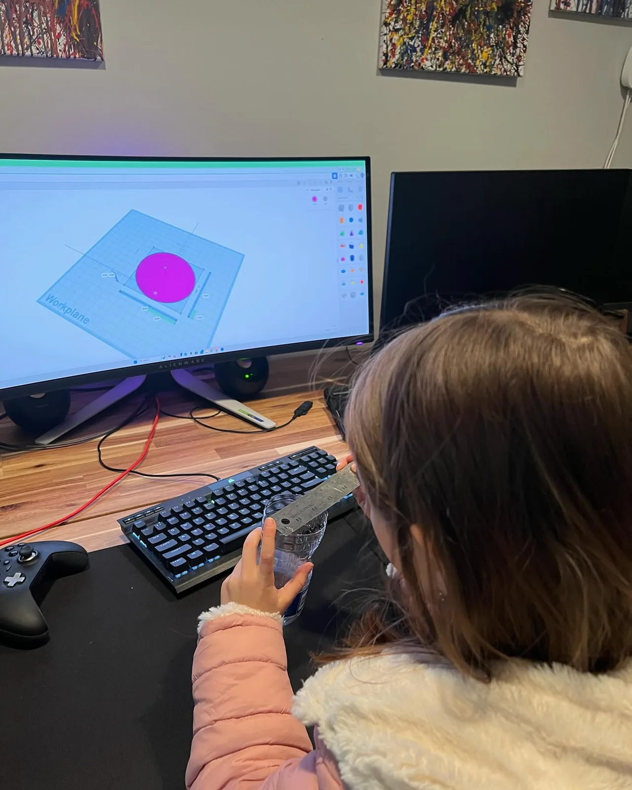 A girl works on a bird feeder design in Tinkercad.