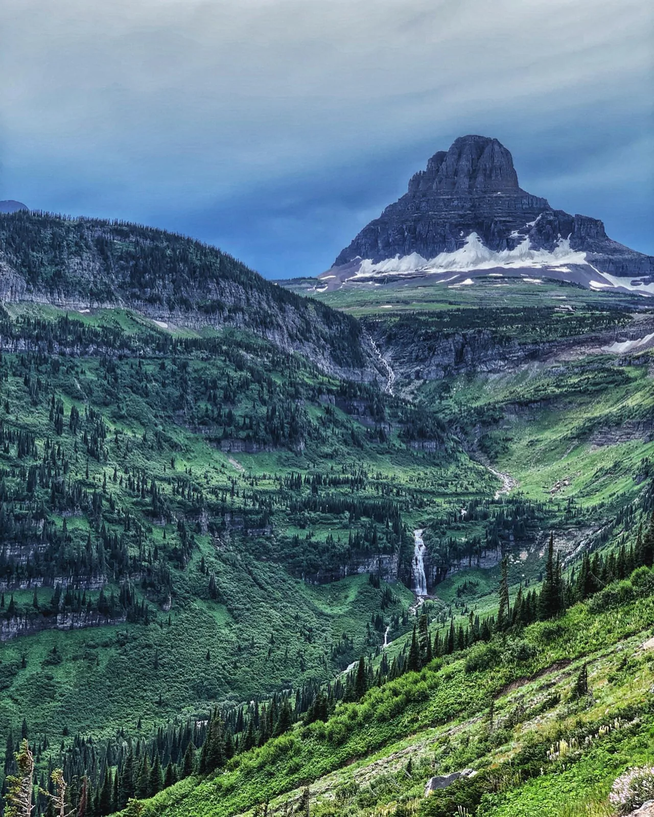 A sharply defined mountain rises above a green valley.