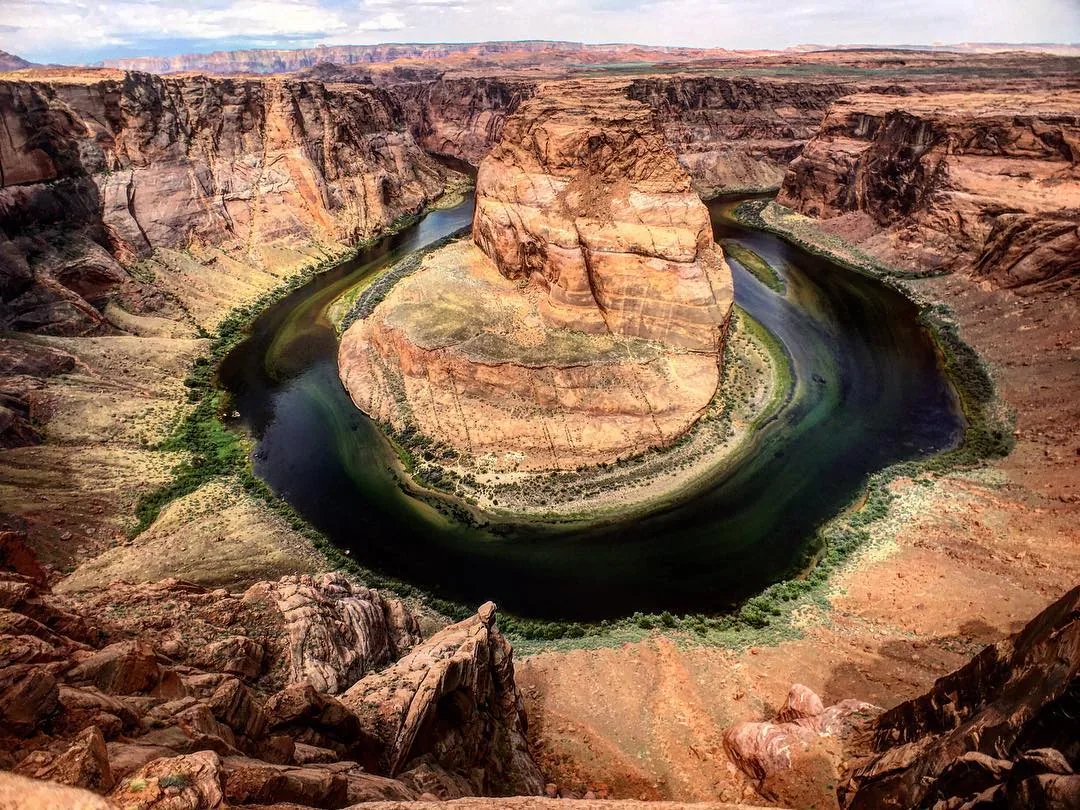 The Colorado River curves around the sandstone cliffs at Horseshoe Bend.