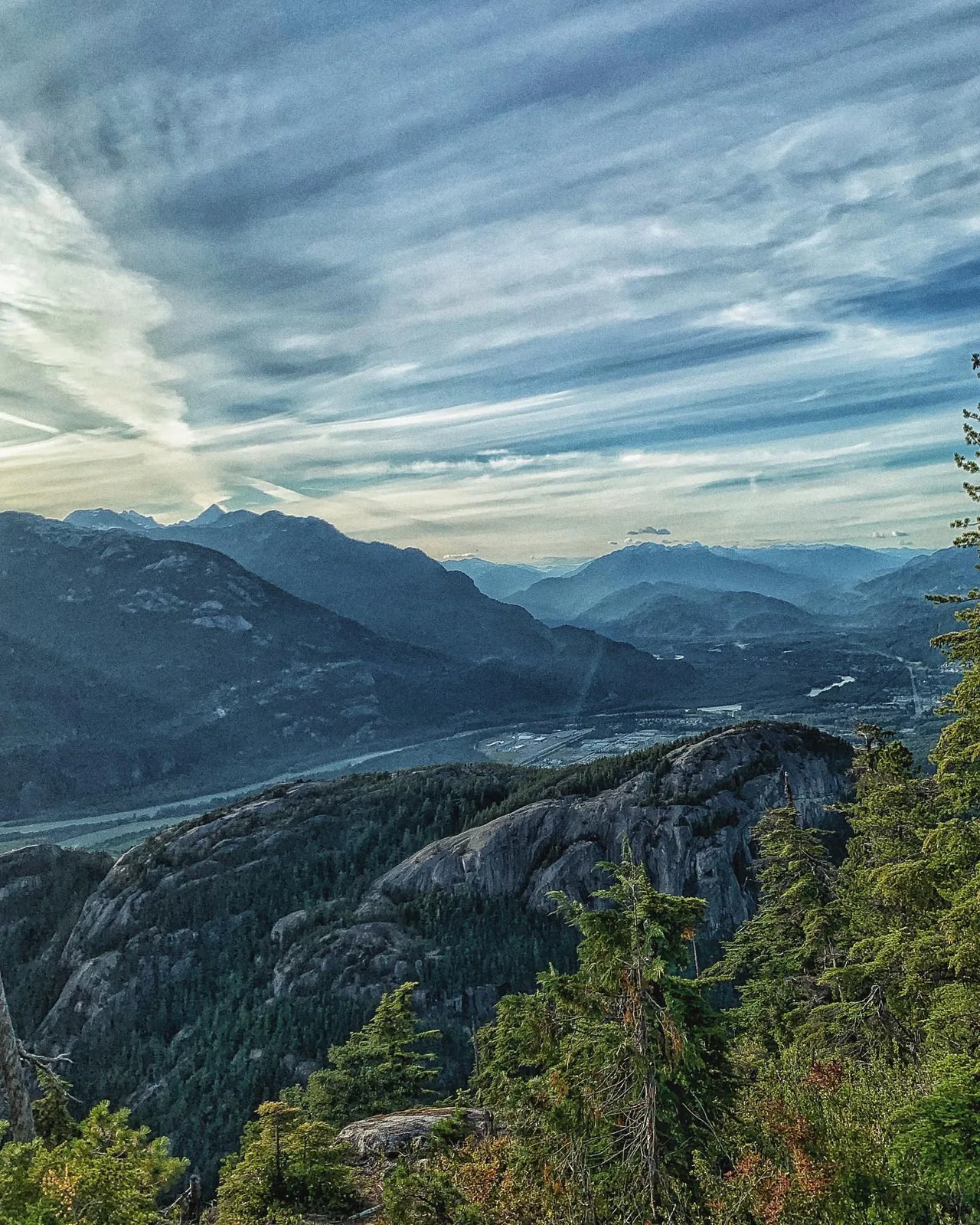 Clouds stretch across a mountain landscape.