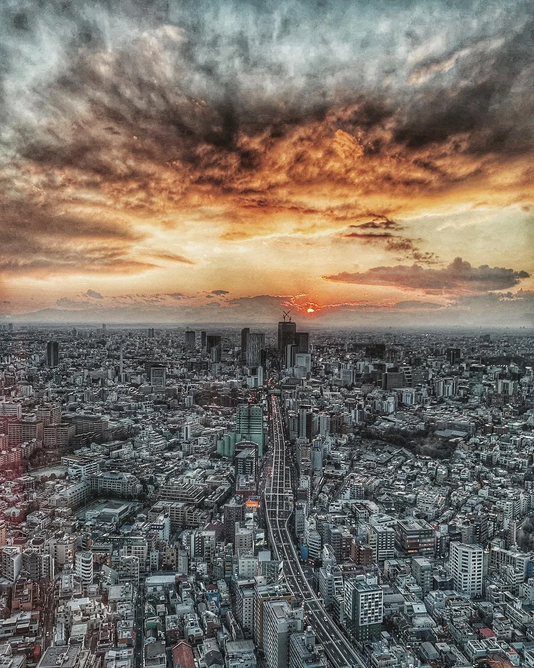 The sun sets beyond the dense cityscape of Tokyo.